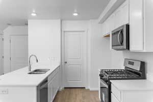 Kitchen featuring white cabinets, stainless steel appliances, laminate, and sink