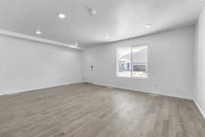 Unfurnished room featuring laminate flooring and a textured ceiling