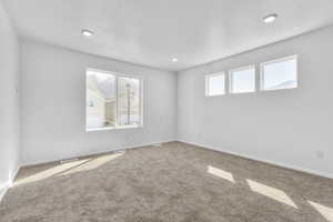 Carpeted spare room featuring a textured ceiling