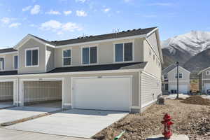 View of front of home with a mountain view and a garage