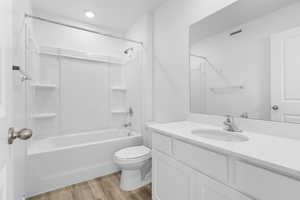 Full bathroom featuring vanity, LVP flooring, shower combination, and toilet