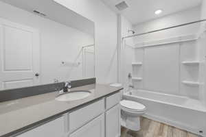 Full bathroom with hardwood / wood-style floors, vanity, toilet, and bathing tub / shower combination