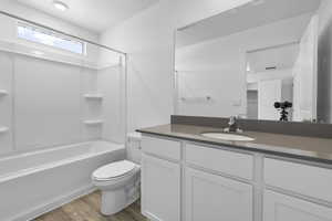 Full bathroom featuring shower / bathing tub combination, vanity, toilet, and wood-type flooring