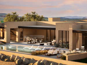 Back house at dusk with outdoor lounge area, a mountain view, and a patio area