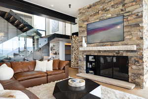 Living room with a stone fireplace and wood-type flooring