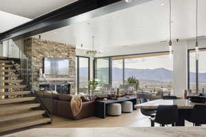 Living room with a stone fireplace, light hardwood / wood-style floors, and an inviting chandelier