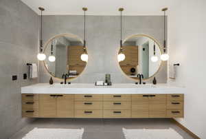 Bathroom with tile patterned floors, vanity, and tile walls