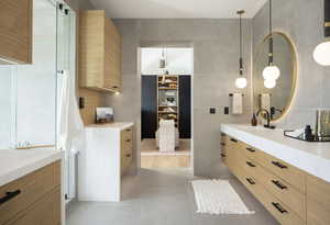 Bathroom featuring tile patterned flooring, vanity, and tile walls