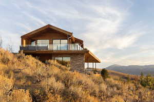 Rear view of house featuring a mountain view and a balcony