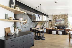 Interior space with a stone fireplace, light hardwood / wood-style floors, and decorative light fixtures