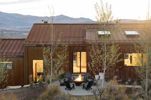 Rear view of property featuring a patio area, a mountain view, and a fire pit