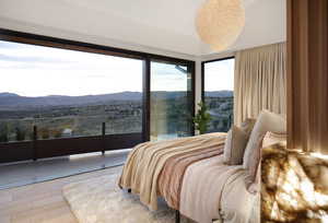 Bedroom with a mountain view, a notable chandelier, and hardwood / wood-style flooring