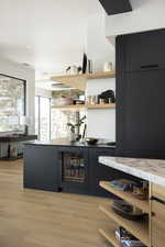 Bar featuring light hardwood / wood-style floors and wine cooler