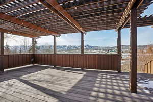 Snow covered deck with a mountain view and a pergola