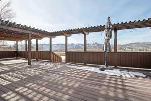 Wooden deck featuring a mountain view and a pergola