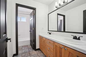 Bathroom with shower / bathtub combination with curtain and vanity