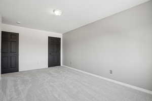 Unfurnished bedroom with light colored carpet