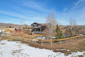 Snow covered back of property with a mountain view