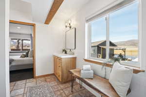 Bathroom featuring a mountain view, beam ceiling, vanity, and a wealth of natural light