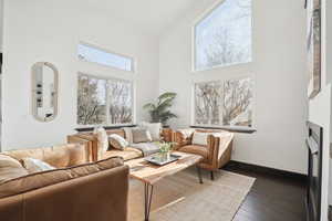 Living room with a towering ceiling and dark hardwood / wood-style floors