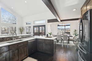 Kitchen featuring refrigerator, sink, stainless steel dishwasher, dark hardwood / wood-style floors, and dark brown cabinetry