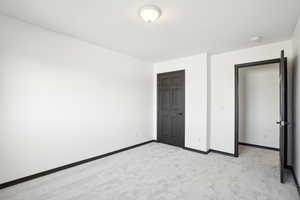 Unfurnished bedroom featuring light colored carpet