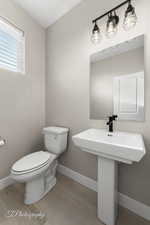 Bathroom with hardwood / wood-style flooring, toilet, and sink