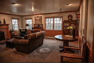 Living room featuring wood walls, a baseboard heating unit, carpet flooring, a textured ceiling, and a fireplace