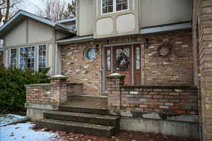 Snow covered property entrance featuring a porch