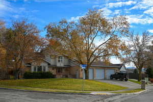 View of front of property with a garage and a front lawn