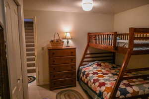 Bedroom featuring light carpet and a textured ceiling