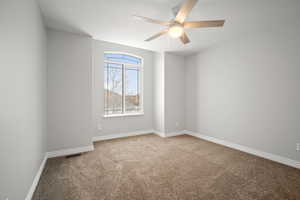 Empty room with carpet and ceiling fan