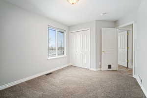 Unfurnished bedroom with a closet and carpet