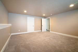 Carpeted spare room featuring a textured ceiling