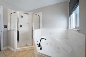 Bathroom featuring tile patterned floors and separate shower and tub