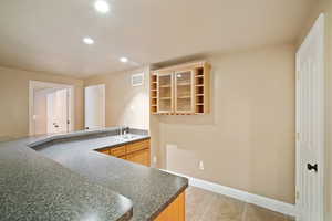 Kitchen featuring light brown cabinetry, sink, and light tile patterned floors