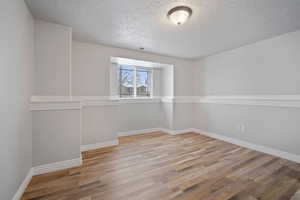 Spare room featuring light hardwood / wood-style floors and a textured ceiling