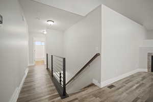 Stairs with a fireplace and hardwood / wood-style flooring