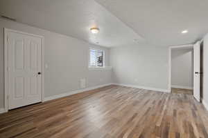 Unfurnished bedroom featuring hardwood / wood-style floors and a textured ceiling