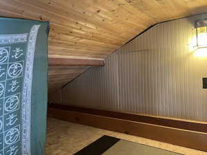 Bonus room featuring wood walls, wood ceiling, and vaulted ceiling