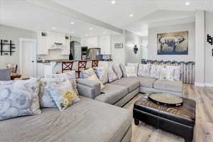 Living room featuring lofted ceiling and light hardwood / wood-style flooring