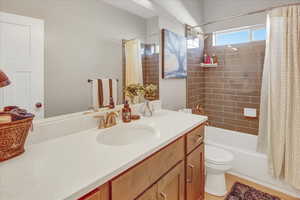 Full bathroom featuring tile patterned flooring, shower / bath combo, toilet, and vanity