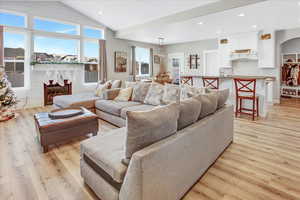 Living room featuring sink, vaulted ceiling, and light wood-type flooring