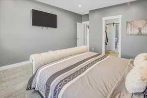 Carpeted bedroom featuring a walk in closet, a barn door, and a closet