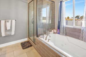 Bathroom featuring shower with separate bathtub, tile patterned floors, and plenty of natural light