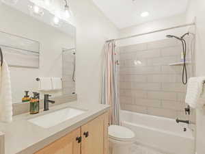 Full bathroom featuring shower / tub combo with curtain, vanity, and toilet