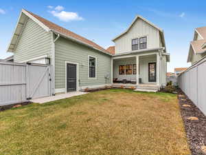 Back of property featuring a porch and a yard