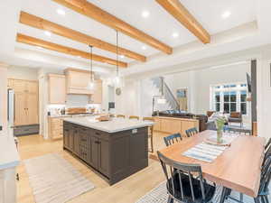 Kitchen featuring a center island, hanging light fixtures, light brown cabinets, and light wood-type flooring