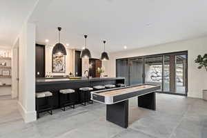 Wet bar  with pendant lighting, a kitchen breakfast bar, and sink