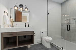 Bathroom with tile patterned floors, vanity, an enclosed shower, and toilet